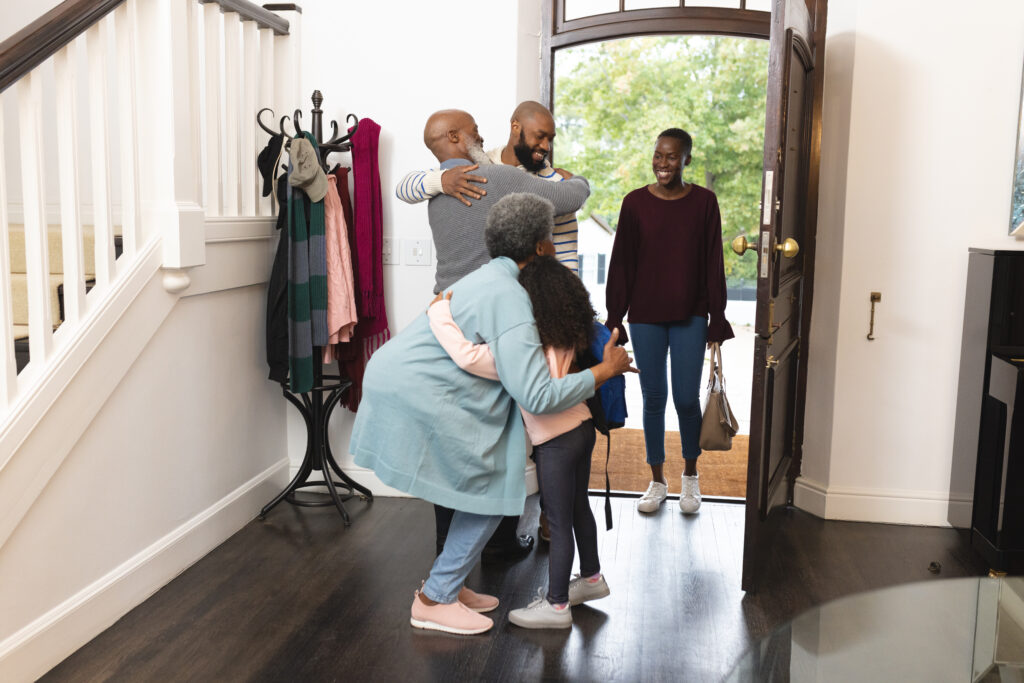 Image of happy multi generation african american family entering house and welcoming each other